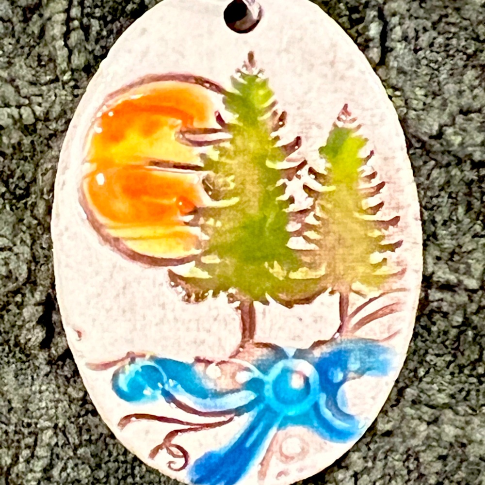 Clay pendant with evergreen tree and sunset